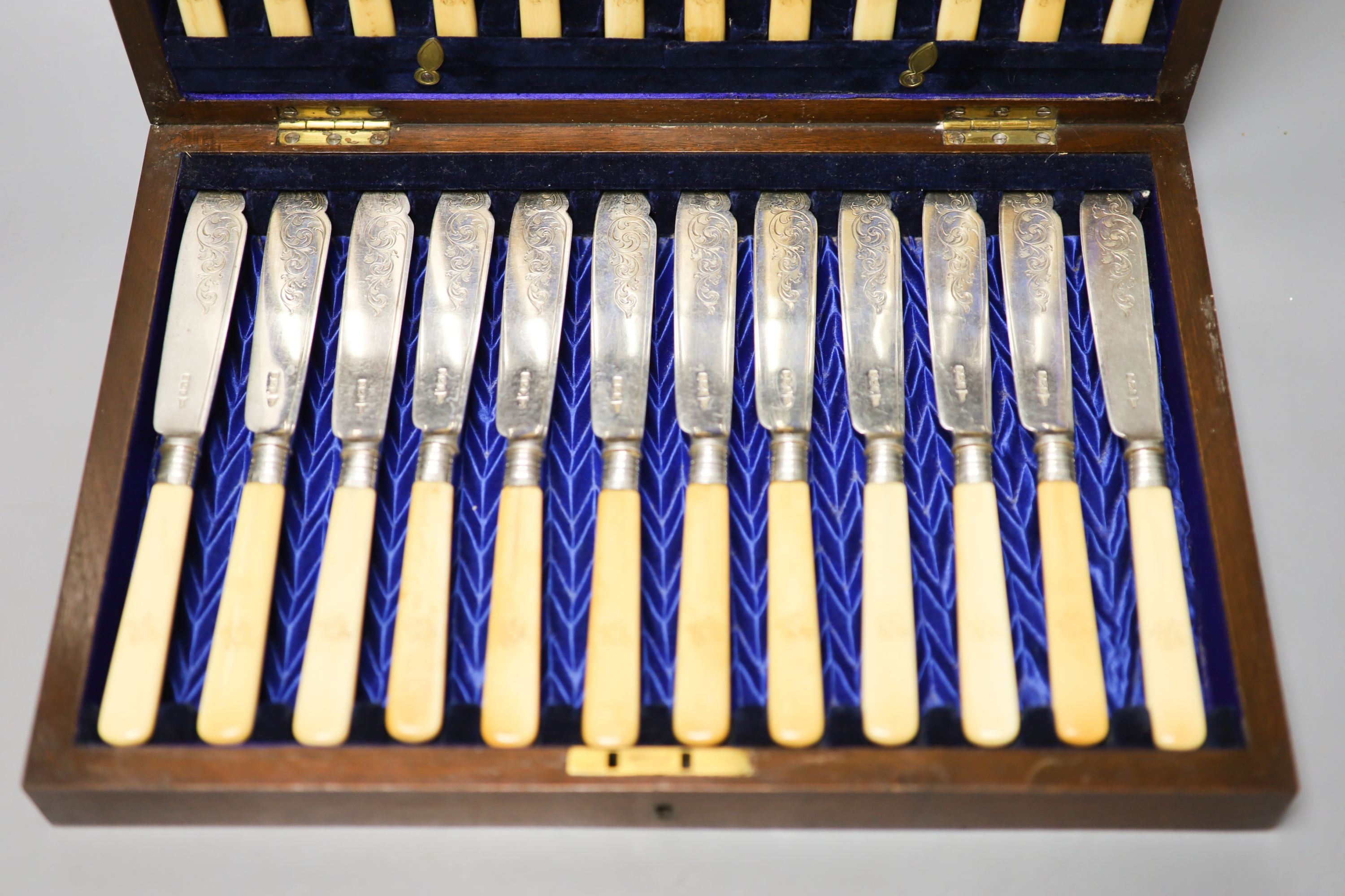 An Edwardian cased set of twelve pairs of ivory handles silver fish eaters, Walker & Hall, Sheffield, 1903.